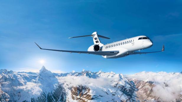 Bombardier Global 8000 fliegt über verschneite Alpen mit klarem Himmel im Hintergrund.