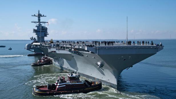 Flugzeugträger USS John F. Kennedy fährt am Meer unter leicht bewölktem Himmel