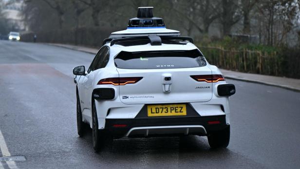 Ein weißer Jaguar mit Waymo-Technologie und dem Kennzeichen LD73 PEZ fährt auf einer Straße.