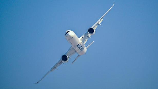 Ein weißes A350-1000 Flugzeug fliegt vor einem wolkenlosen, blauen Himmel.