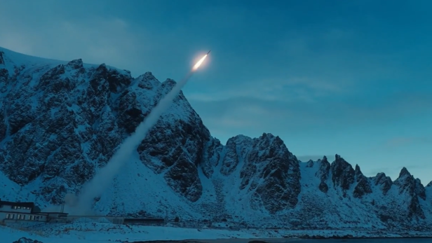 Raketenstart vor schneebedeckten Bergen und Küste bei winterlicher Dämmerung.