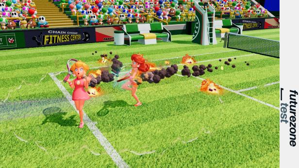 Zwei Spielfiguren spielen Tennis auf einem brennenden Rasenplatz vor buntem Publikum.