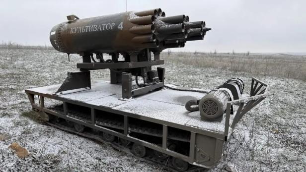 Ferngesteuertes Kettenfahrzeug mit montierten Raketen-Startbehältern auf verschneitem Feld.