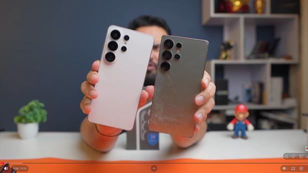 Ein Mann hält 2 Smartphones in die Kamera, eines ist weiß, das andere grau
