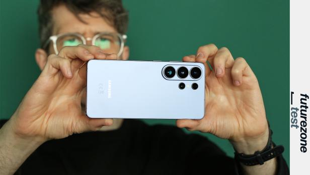 Eine Person hält ein Smartphone im Querformat und fotografiert gerade etwas
