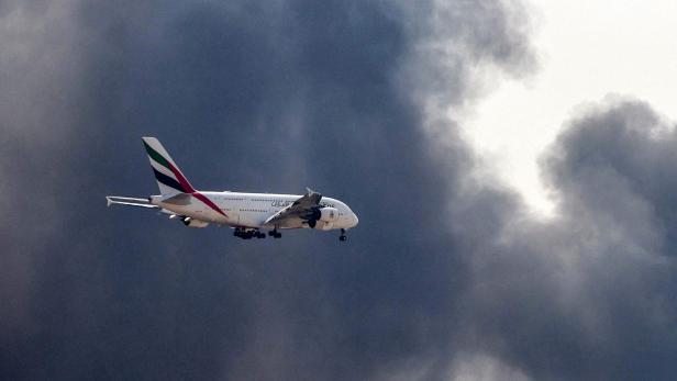 Emirates-A380 landet neben dichten Rauchschwaden.