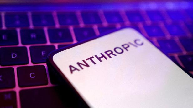 Auf einem Smartphone-Bildschirm steht „ANTHROPIC“, das Gerät liegt auf einer beleuchteten Tastatur.