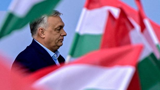 Viktor Orbán im Profil, umgeben von ungarischen Flaggen.