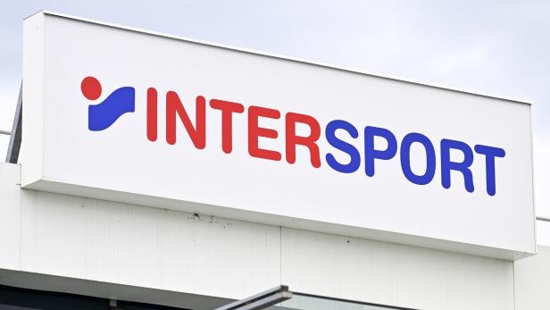 Ein Schild mit dem Schriftzug „INTERSPORT“ in roten und blauen Buchstaben sowie einem blauen und roten Logo.