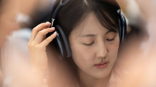 Eine Person hört Musik über Apple AirPods Max Kopfhörer
