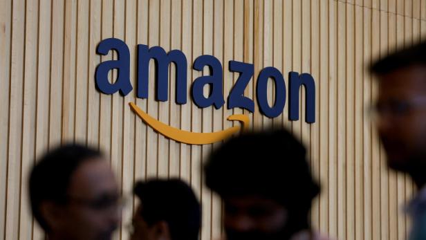 Amazon Logo mit Köpfen  im Vordergrund.