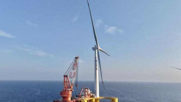 Die schwimmende 16-Megawatt-Windkraftanlage der Three Gorges Corporation (CTG) steht auf einer gelben Plattform weit vor der Küste im Meer.