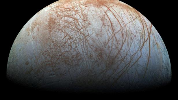 Der Jupitermond Europa zeigt eine eisige Oberfläche mit rötlichen Rissen und Strukturen.
