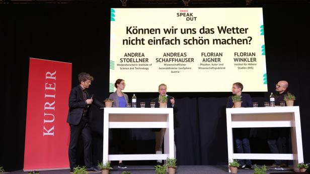 Fünf Personen diskutieren auf einer Bühne vor einer großen Leinwand mit der Frage „Können wir uns das Wetter nicht einfach schön machen?“.