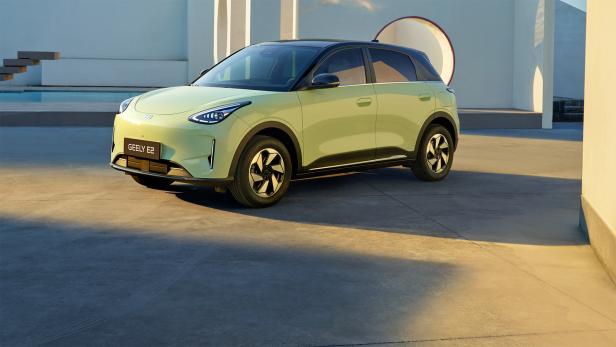 Geely E2 in Hellgrün vor moderner Architektur.