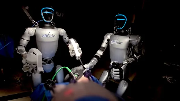 Zwei humanoide Roboter bei einer Operation.
