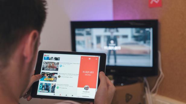 Mann hat YouTube auf 2 Bildschirmen geöffnet