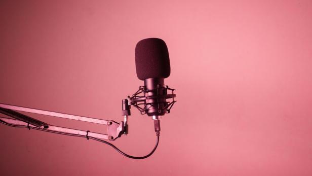Podcast-Mirko vor rotem Hintergrund. 