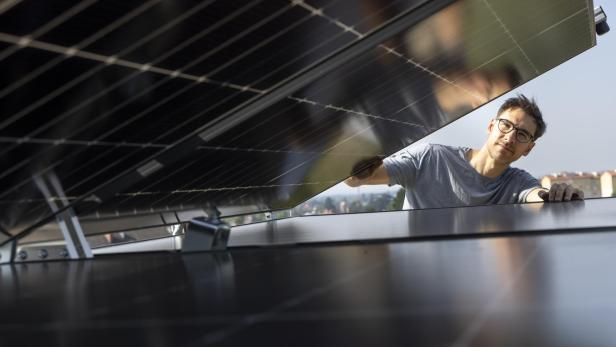 Ein Mann klappt ein Solarzpaneel auf 
