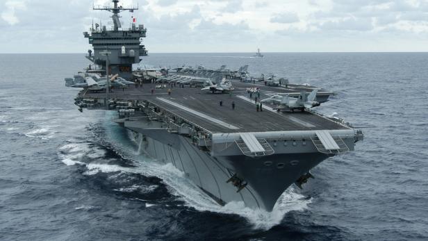 Flugzeugträger USS Enterprise auf hoher See mit Jets auf dem Deck.