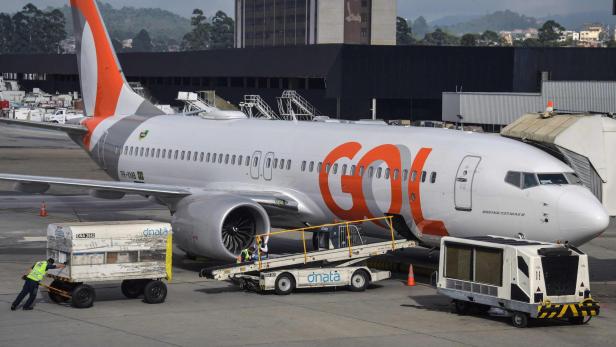 Passagierflugzeug von Gol auf dem Vorfeld, umgeben von Gepäckwagen und Wartungspersonal.