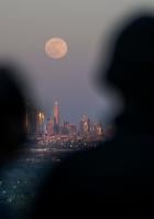 People watch the full moon, known as the "Super Pink Moon", as it rises over the skyline of New York and Empire State Building, as seen from West Orange, in New Jersey