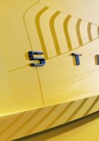 Detailansicht des Schriftzugs „ASTRA“ auf einem gelben Auto.