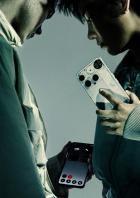 Zwei Personen betrachten zwei „Nothing Phone“-Smartphones.