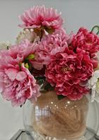 Ein Arrangement aus rosa und roten Pfingstrosen in einer Glasvase.