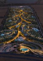 Eine Luftaufnahme der beleuchteten Khalid-Bin-Sultan-Stadt in der Nacht.