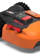 Ein orangefarbener „Landroid“-Mähroboter der Marke Worx steht auf einer weißen Fläche.
