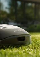 Ein grauer Rasenmähroboter der Marke Stiga steht auf einem Rasen.