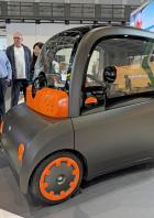 Ein elektrisches Microcar von Astraux wird von mehreren Personen betrachtet.
