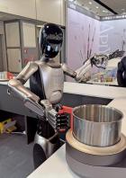 Der Küchenroboter Robbyant hantiert mit einem Topf.