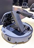 Der Dreame Cyber 10 Ultra Saugroboter mit geöffnetem Deckel und ausgefahrenem Arm.