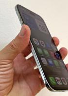 Eine Hand hält ein iPhone mit verschiedenen Apps auf dem Bildschirm.