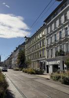 Eine Straßenbahnhaltestelle in einer Wiener Wohngegend an einem sonnigen Tag.