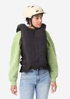 Eine Frau trägt die schwarze, ärmellose Airbag-Weste von Decathlon und In&motion mit sichtbarer Elektronik am Rücken.