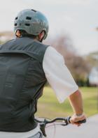 Ein Mann trägt die schwarze, ärmellose Airbag-Weste von Decathlon und In&motion mit sichtbarer Elektronik am Rücken.