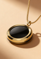 Der smarte Anhänger „The Gem“ von The90 mit goldener Kette misst UV-Strahlung und warnt vor zu viel Sonne.