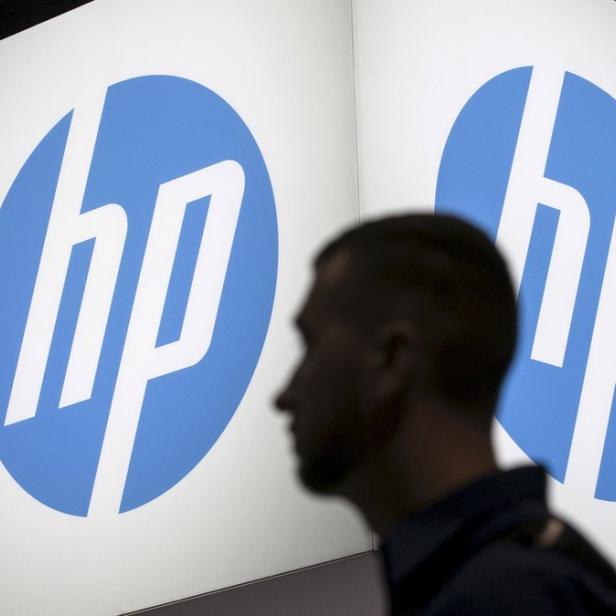Ein Mann geht an zwei großen HP-Logos vorbei.