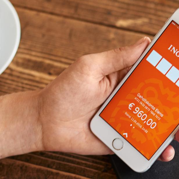 Eine Person hält ein Smartphone mit der App der ING DiBa in der Hand. Der Kontostand beträgt 960 Euro.