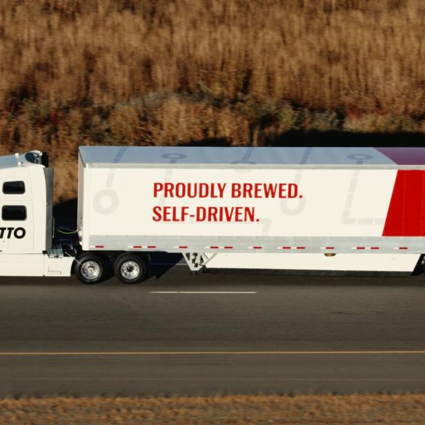 Ein weißer Lkw mit „Budweiser“- und „Otto“-Logos fährt auf einer Straße.