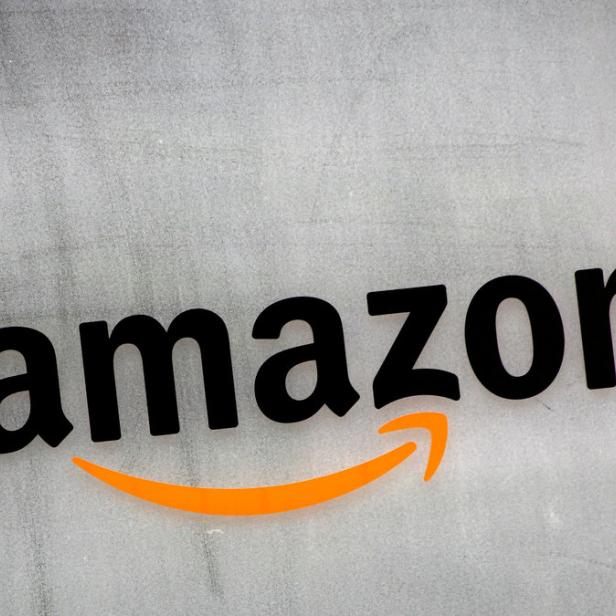 Das Amazon-Logo auf einer grauen Wand.