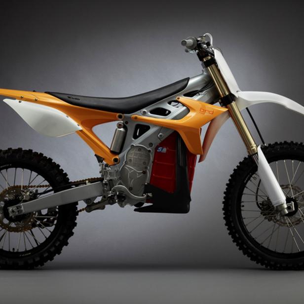 Ein orangefarbenes und silbernes Dirtbike vor einem grauen Hintergrund.