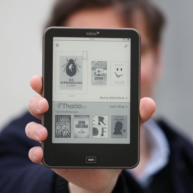 Eine Person hält ein Tolino E-Reader mit dem Buch „Die Verwandlung“ von Franz Kafka auf dem Bildschirm.