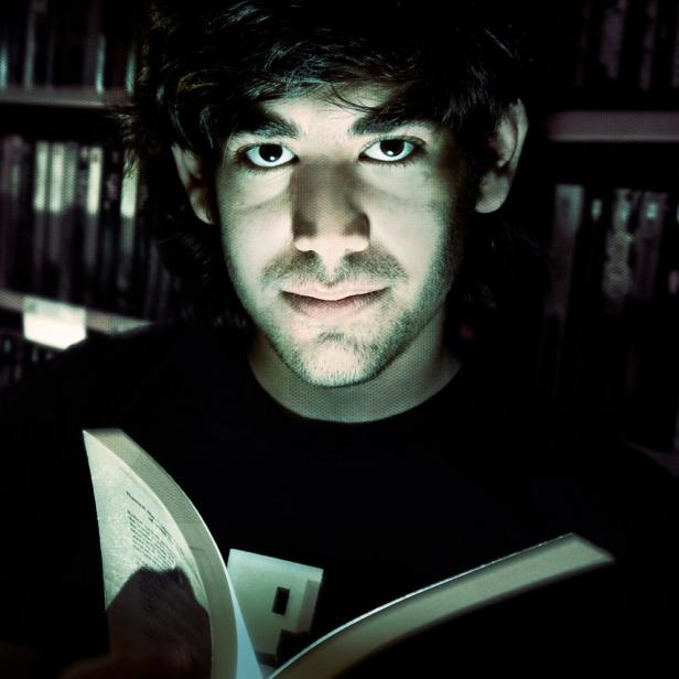 Ein Mann liest ein Buch vor einem Bücherregal mit Titeln wie „House of Moons“.