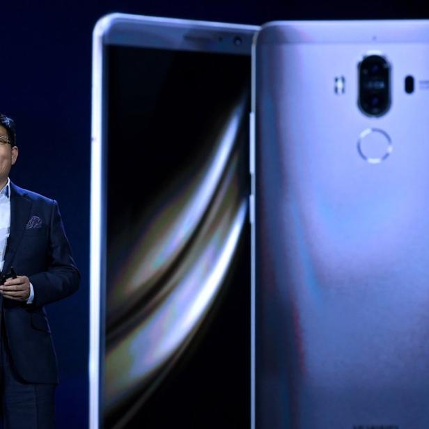 Ein Mann in Anzug präsentiert ein neues Huawei Smartphone auf einer Bühne.