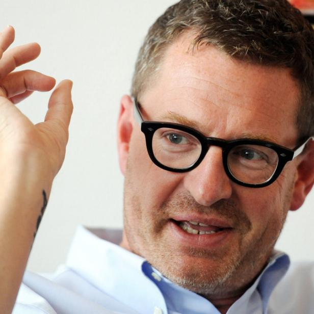 Ein Mann mit Brille gestikuliert mit der Hand.