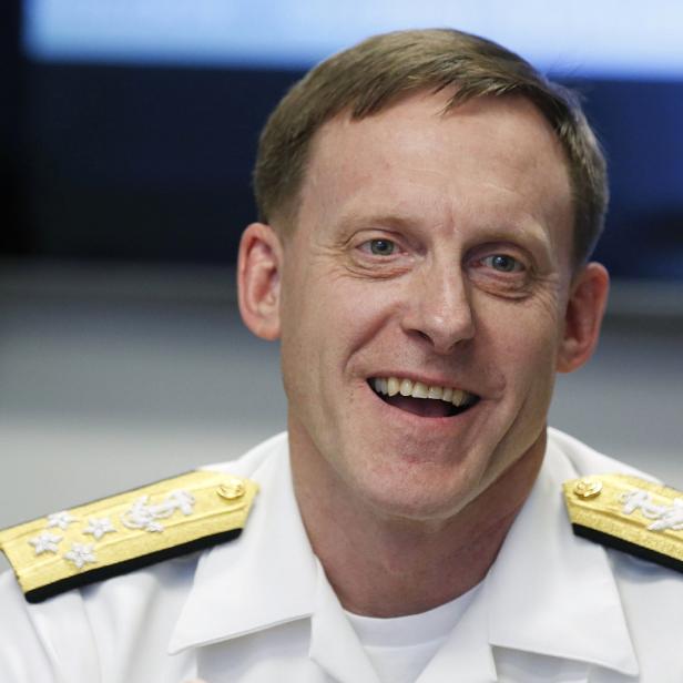 Ein lächelnder Mann in Marineuniform mit goldenen Schulterstücken.